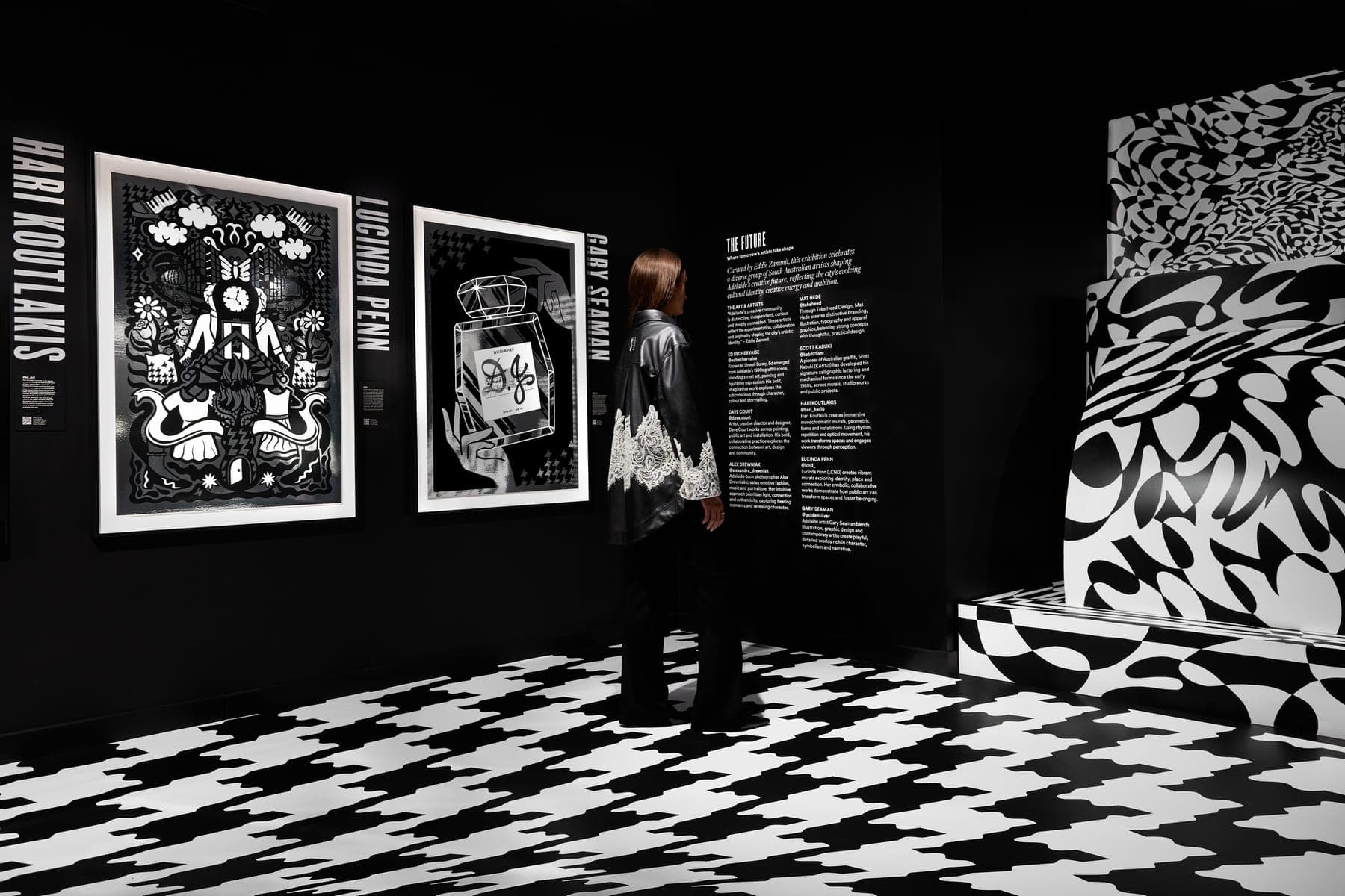 A visitor in a black and white gallery with a patterned floor